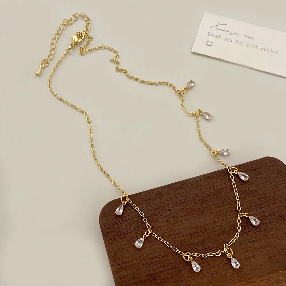 Women's zircon jewellery set showing geometric pendant necklace, matching earrings, and anklet with meteor shower design