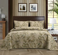 Blue American floral and bird pattern quilted cotton bedspread set of three pieces on a bed.