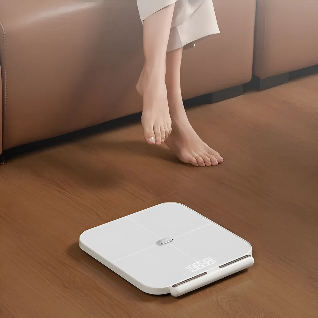 White professional body fat scale with 8 electrodes on tempered glass platform, LED display showing weight measurement