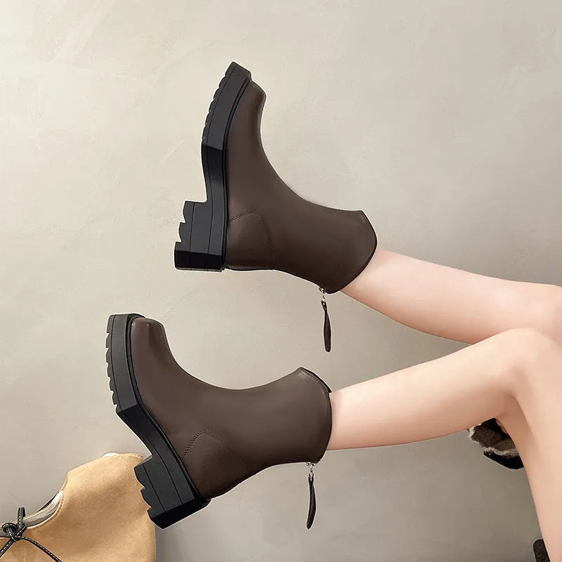 Women's black platform Martin ankle boots with a square toe, chunky sole, and back zipper.