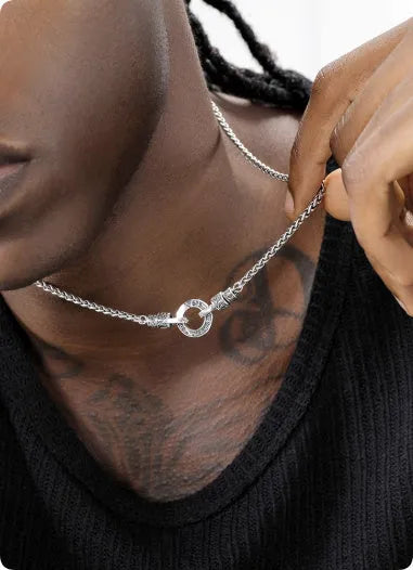 Close-up of a women's sterling silver clavicle necklace with a classic chain, shown against a neutral background.