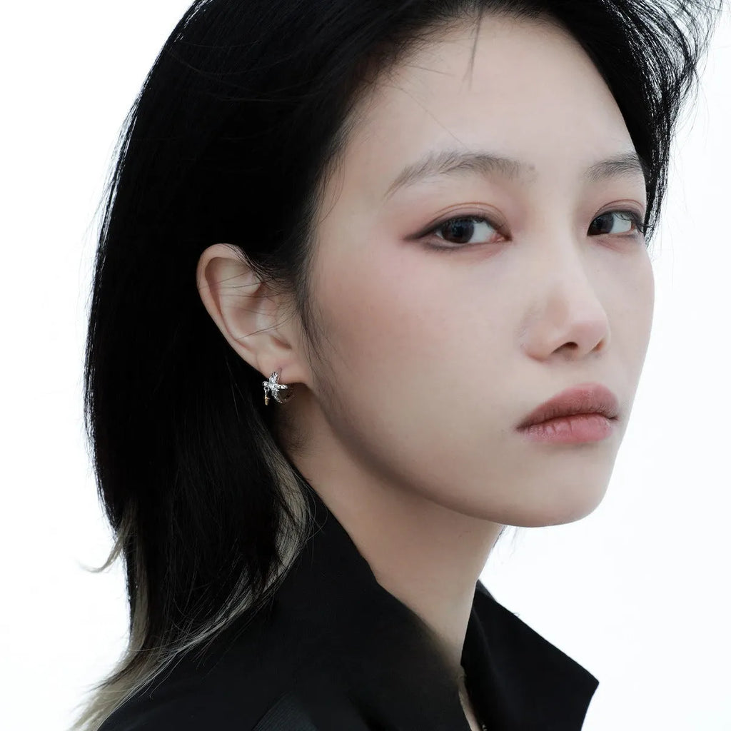 XINGX geometric cross earrings in 925 silver with white gold electroplated finish and circular detail.