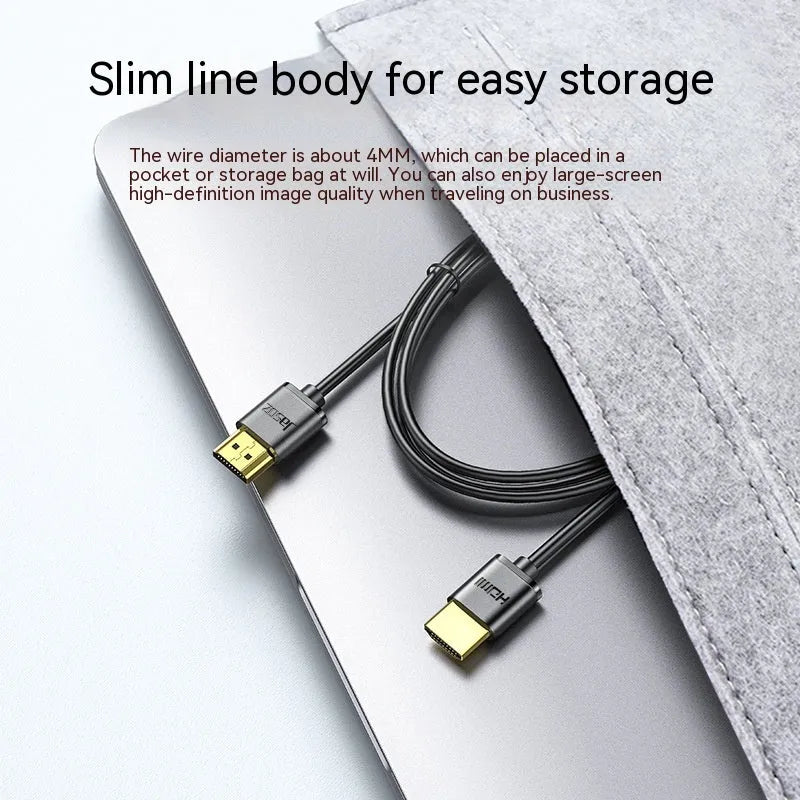 Thin flexible HDMI video cable with gold-plated connectors on a white background.