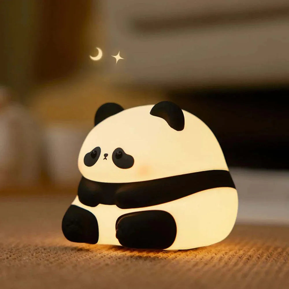 Panda shaped silicone night light with warm white glow on dark surface