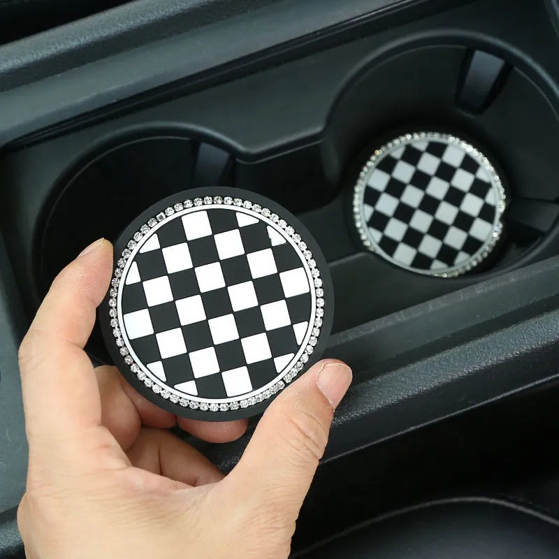 Black and white checkerboard PVC car cup holder mat inserted into vehicle centre console slot