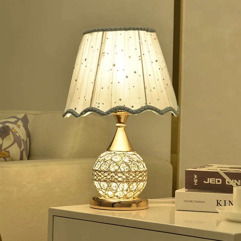 Gold crystal desk lamp with iron art base on a wooden table