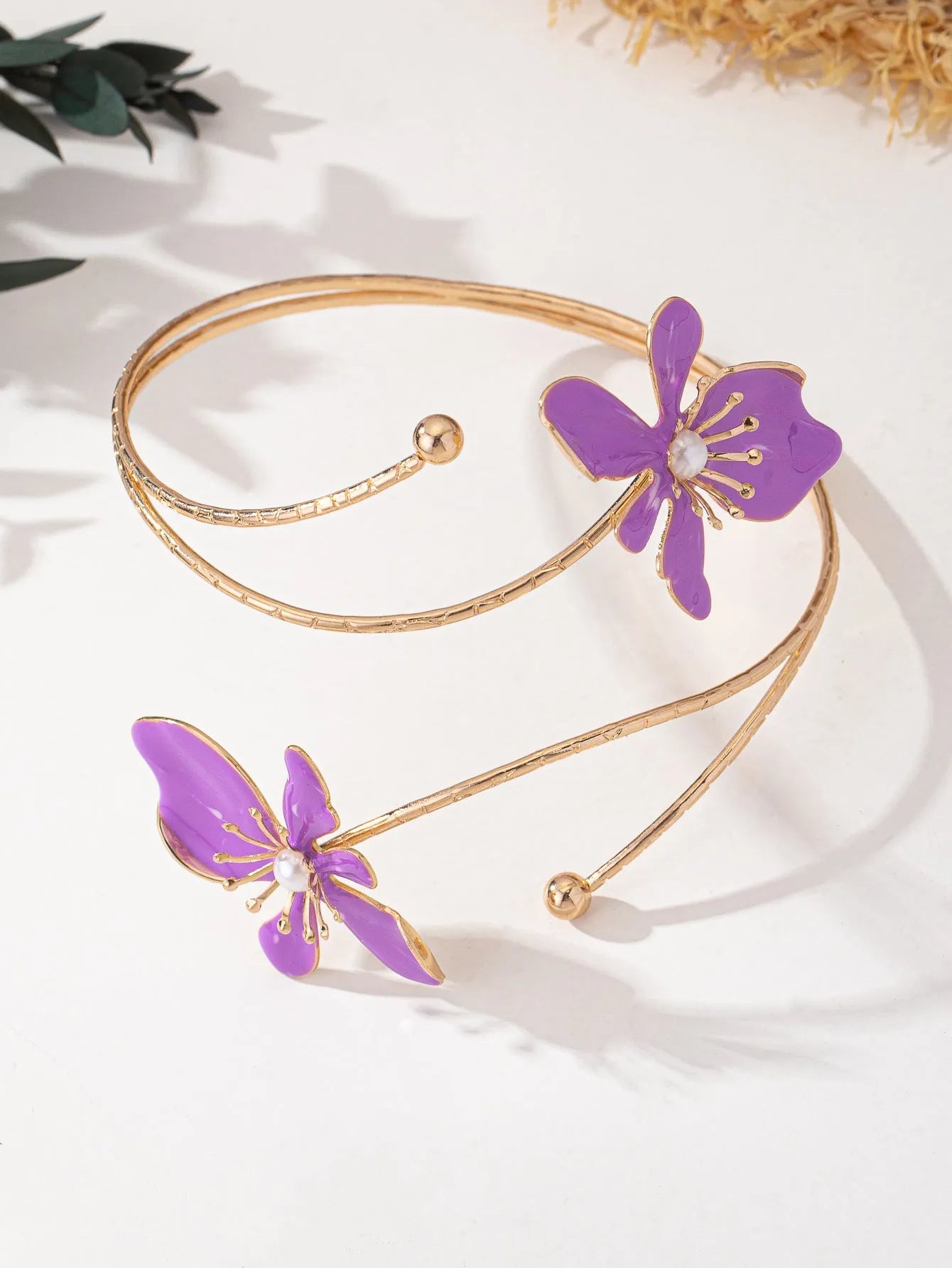 Pink alloy fashion armband with a hollow, openwork pattern shown on a wrist.
