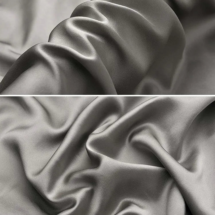 Dark grey envelope closure silk pillowcase on a bed.