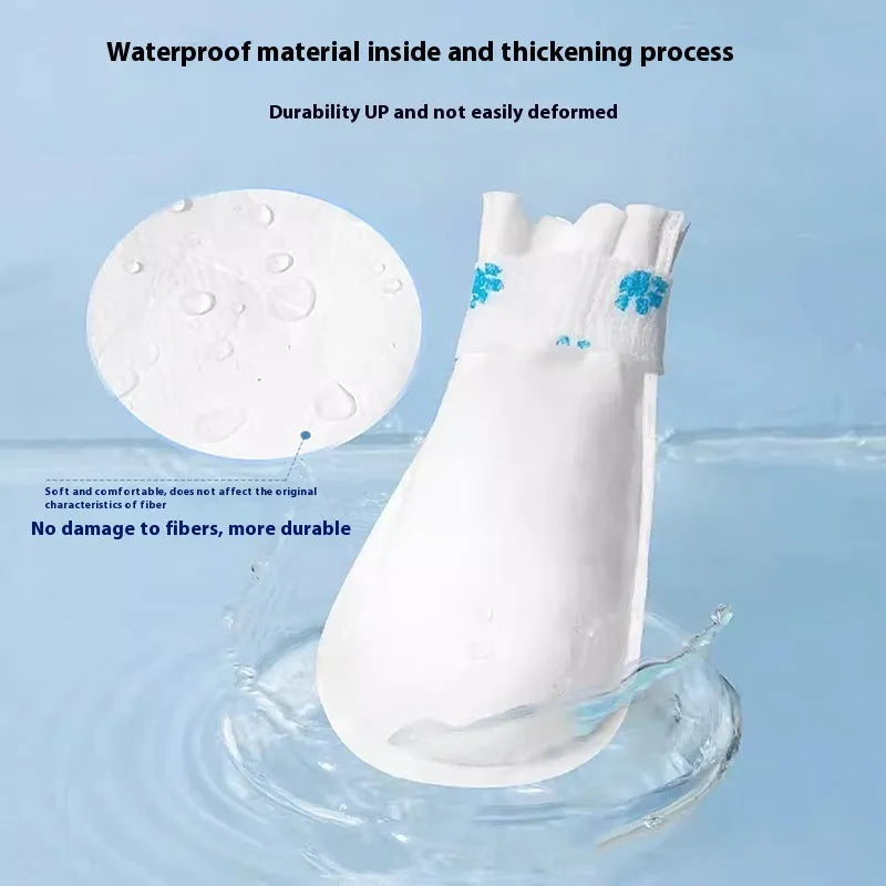 White disposable waterproof shoe covers for small and medium dogs on a non-slip surface.