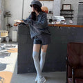 Women's knitted suit set showing cable knit geometric pattern on long sleeve sweater and matching elastic waist shorts