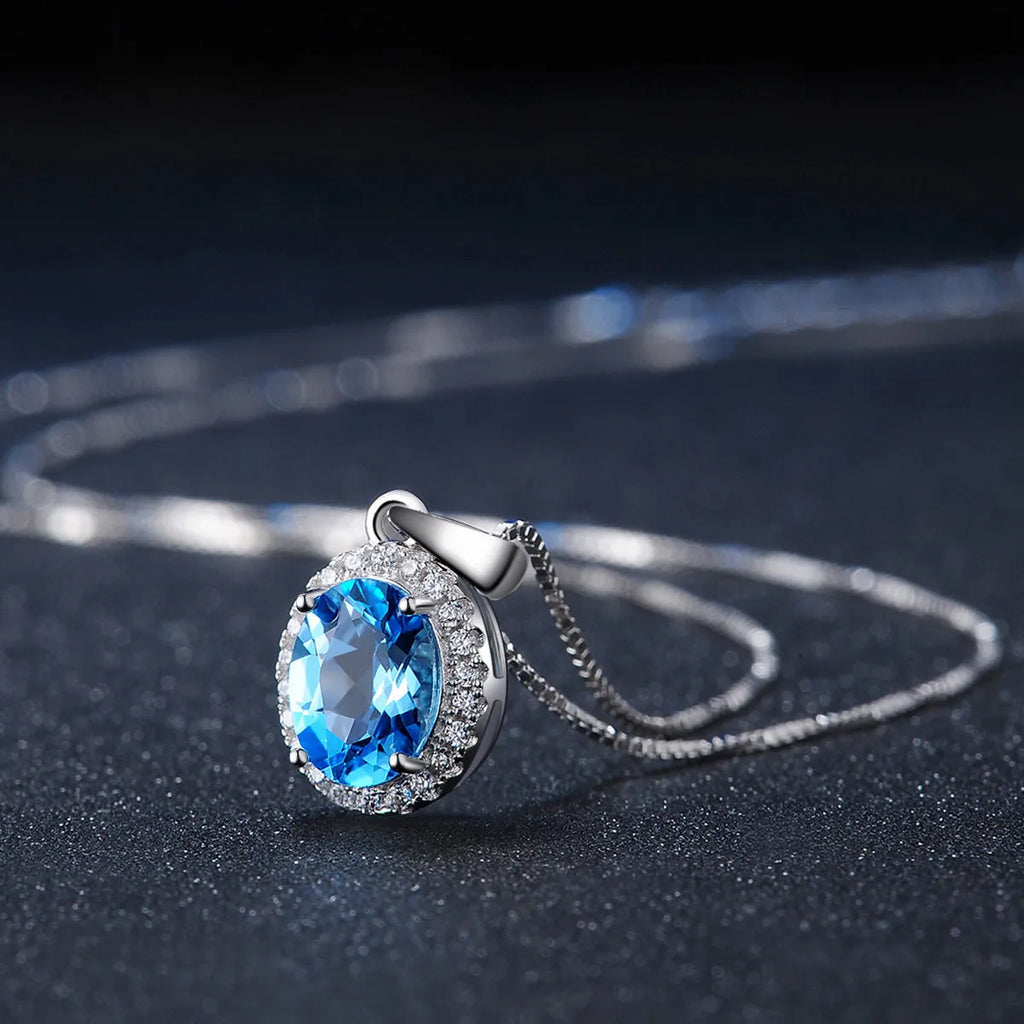 Four-piece 925 sterling silver jewellery set with blue topaz stones: geometric necklace, earrings, ring, and pendant.