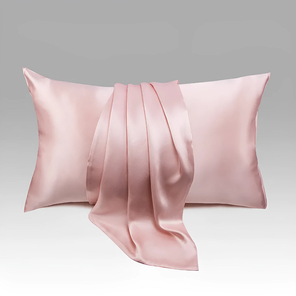 Dark grey envelope closure silk pillowcase on a bed.