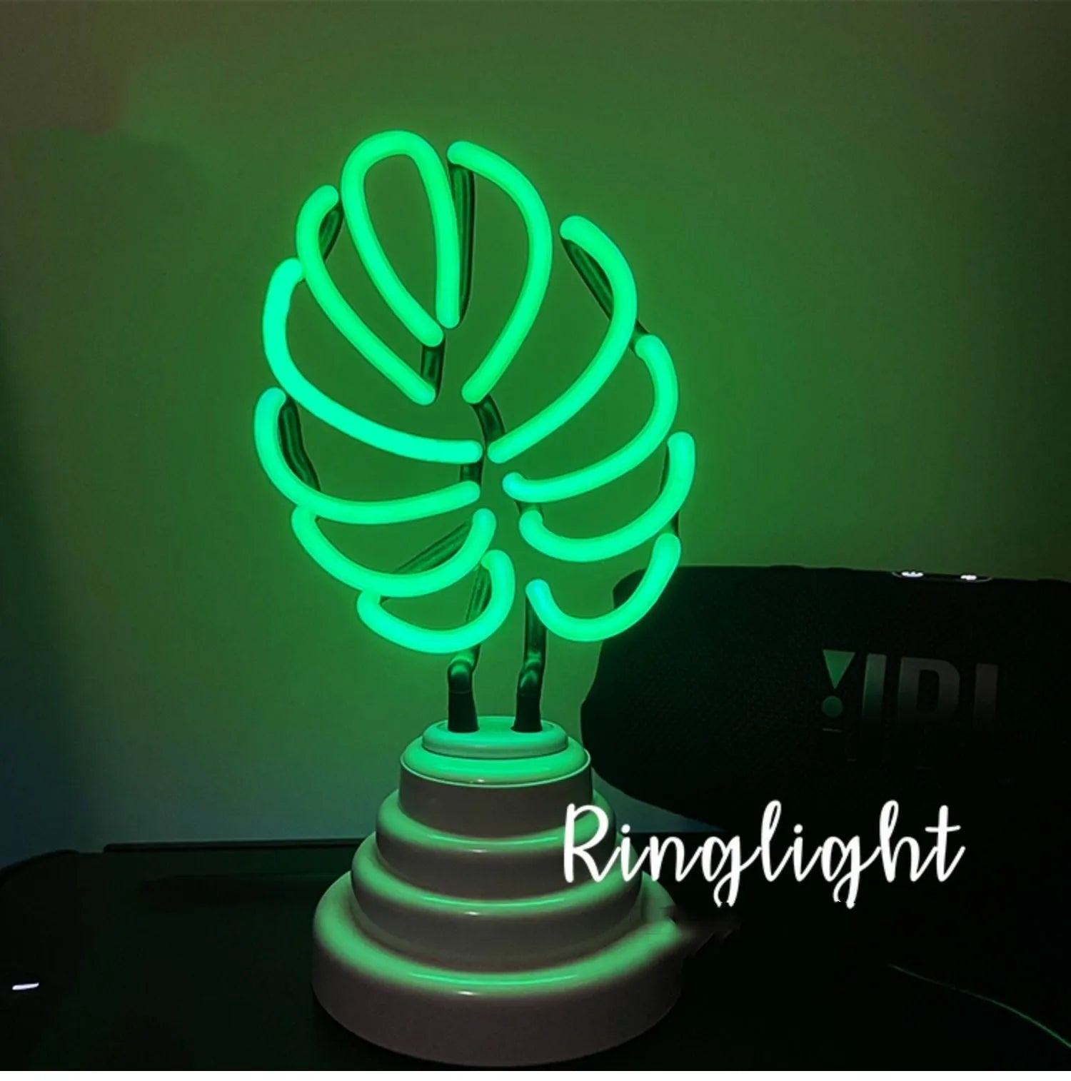 Minimalist bamboo-shaped white desk lamp with green illumination on wooden desktop