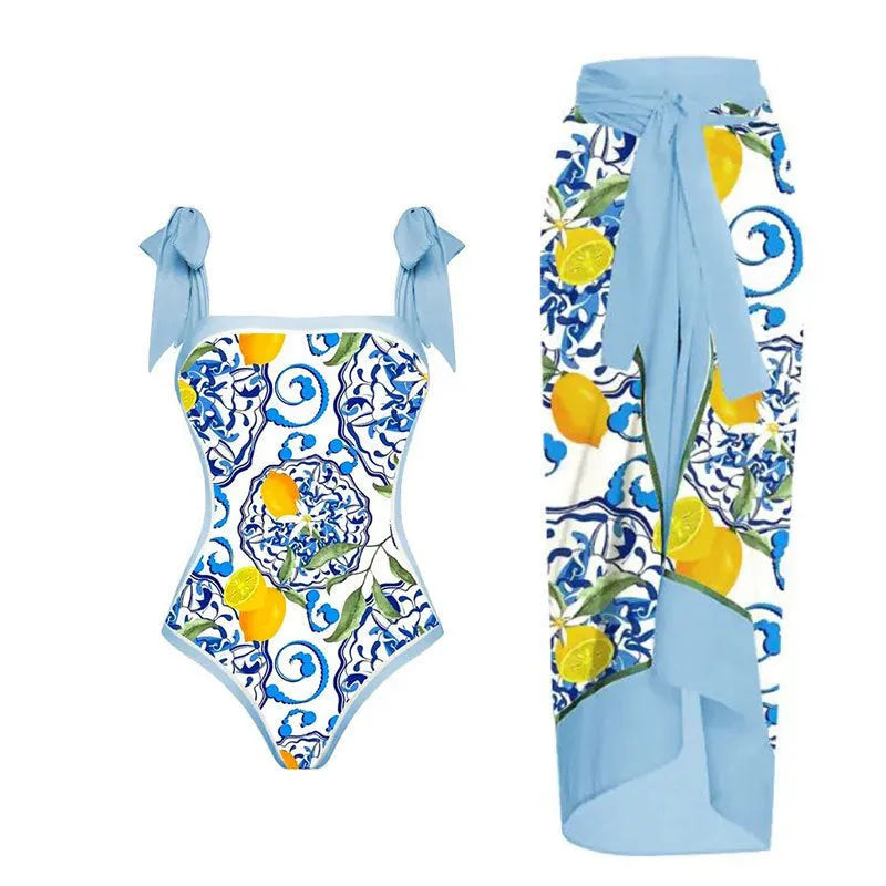 Women's yellow one-piece swimsuit with floral pattern and matching white chiffon skirt.