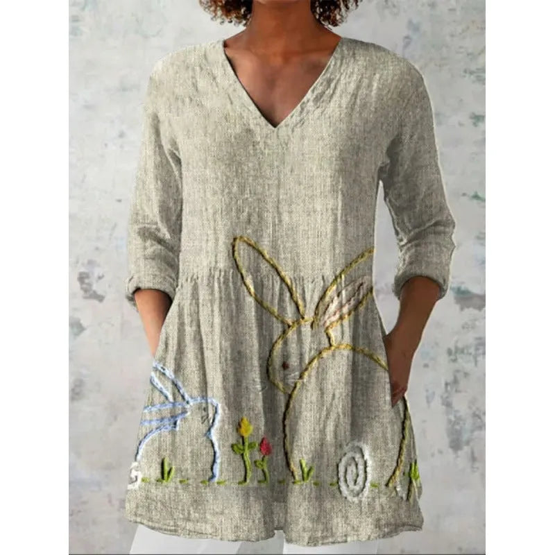 A woman modelling a printed, loose-fitting dress with a wide waist and three-quarter length sleeves.