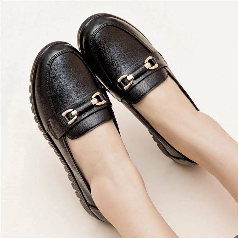 Black leather pumps with soft rubber soles, microfibre upper, and low flat heels on a white background