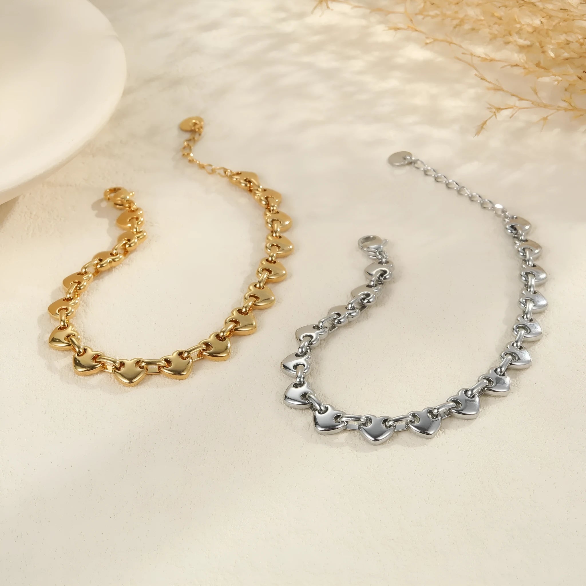 Stainless steel bracelet with a hollowed-out heart charm in a gold electroplated finish.