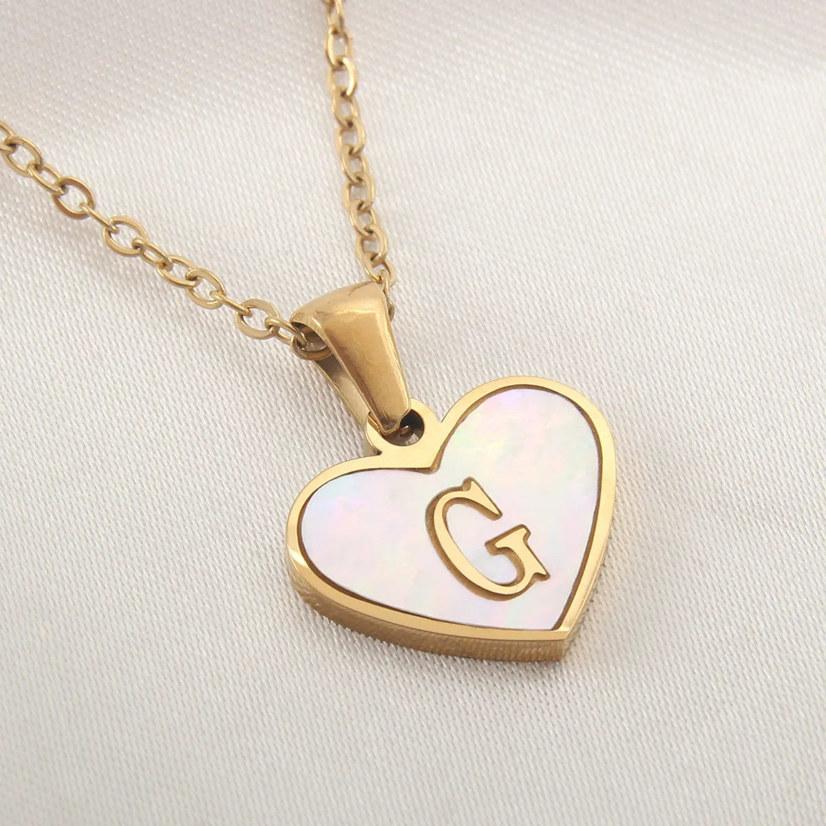 Gold heart necklace with white shell detail and personalised initial letter on adjustable chain