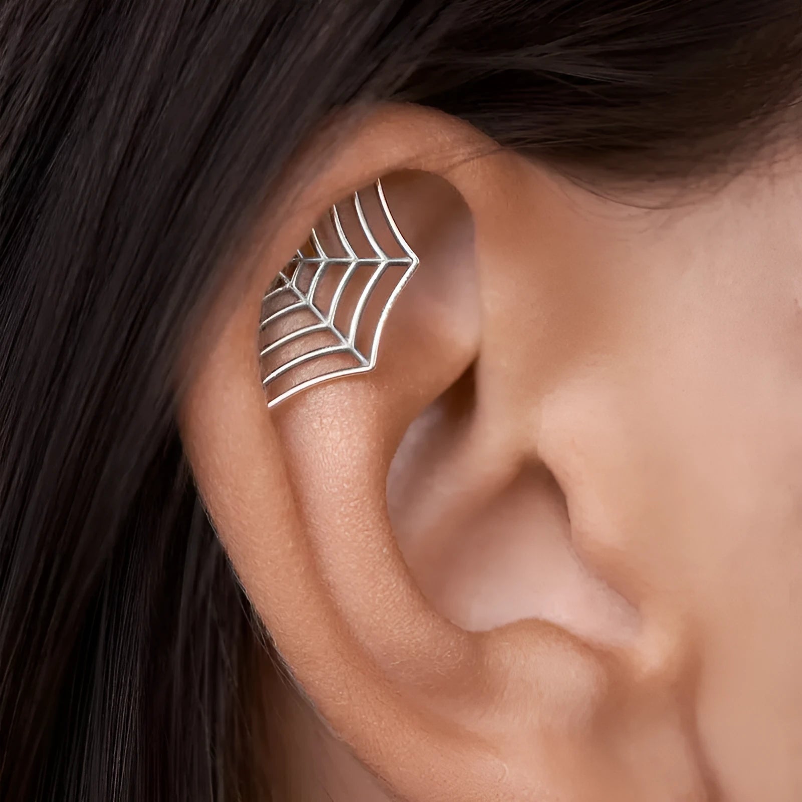 Spider web design metal stud earrings in gold or silver electroplated finish.
