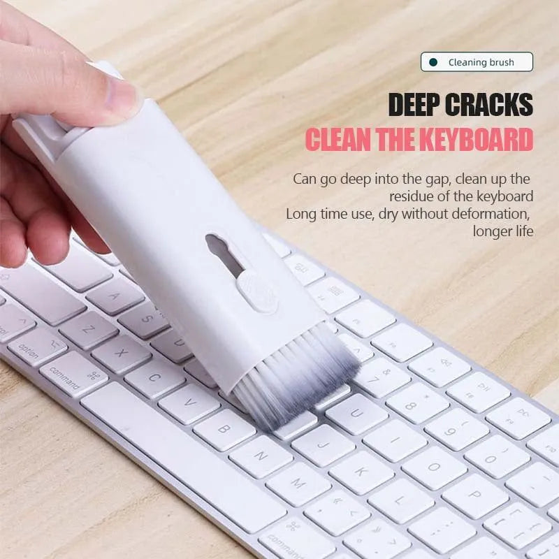 White cleaning set with pen, brush, keycap puller, and spray bottle on desk