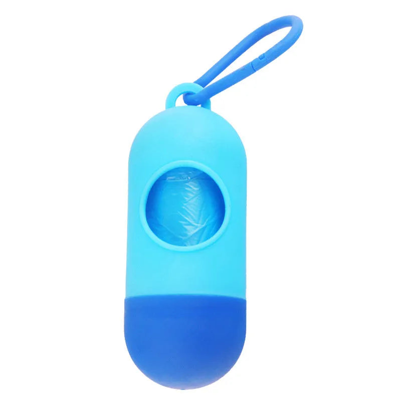 Compact black dog waste bag dispenser with a metal hook and Velcro strap, shown attached to a dog lead.