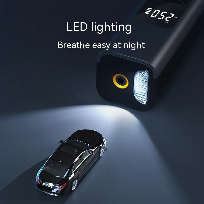 Black cylindrical wireless digital display car air inflator pump with vacuum hose and attachments on a grey background.