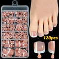 Box of 120 French white edge nude false toe nail pieces in assorted shades on a table
