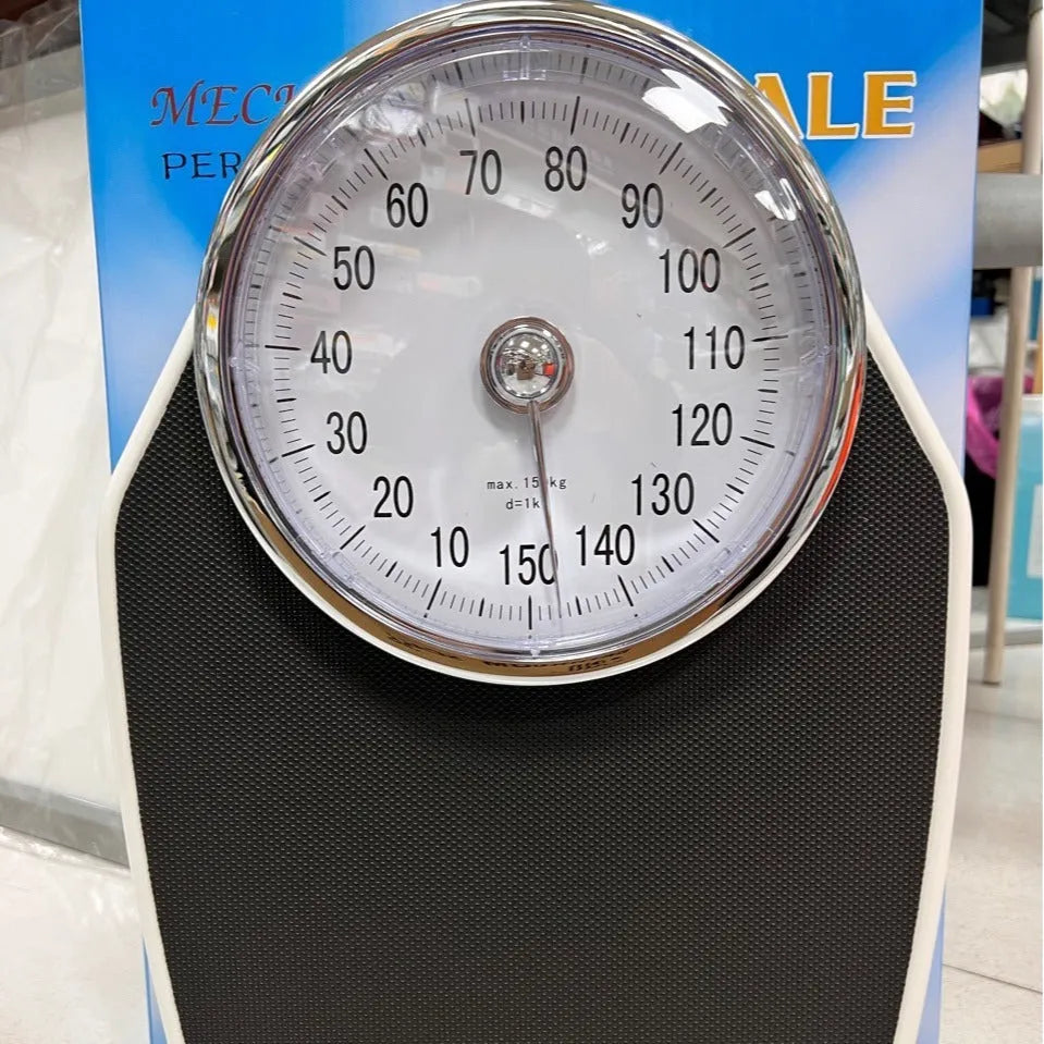 Black mechanical body weight scale with large dial and pointer on a simple platform.