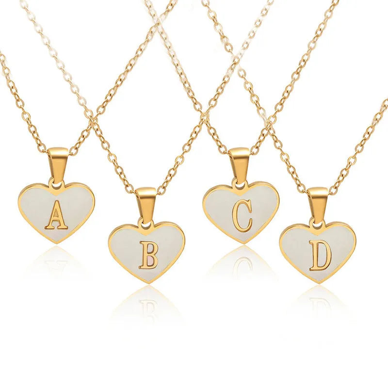 Gold heart necklace with white shell detail and personalised initial letter on adjustable chain