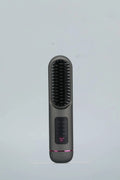 A white portable negative ion hair comb with USB charging port on a dark surface.