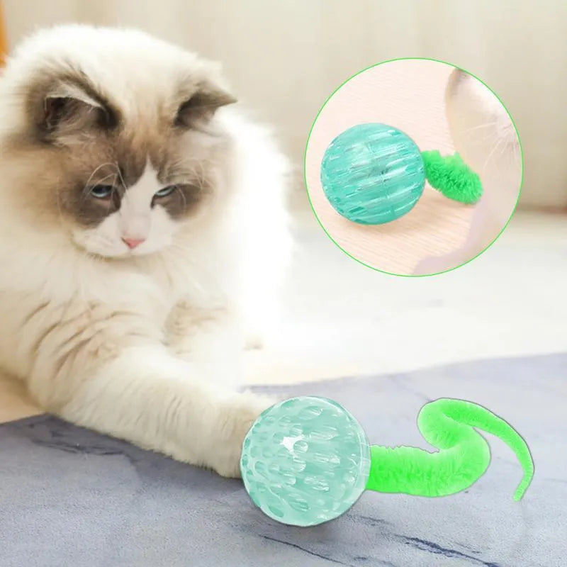 Interactive cat toy with purple bouncy ball and plush tail on wooden floor