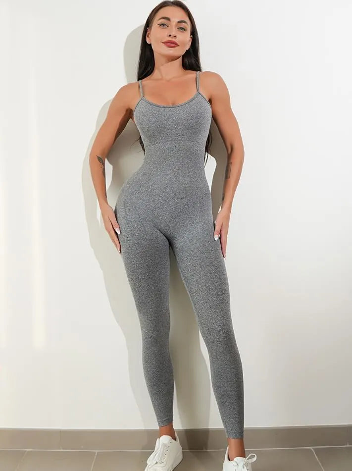 Woman wearing a black sleeveless unitard jumpsuit with spaghetti straps, showcasing the form-fitting tummy control design.