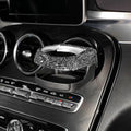 White diamond-encrusted ABS plastic car cup holder bracket mounted on a car air vent.