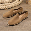 Handmade grey men's low-top leather shoes with a flat wedge rubber sole on a plain background.