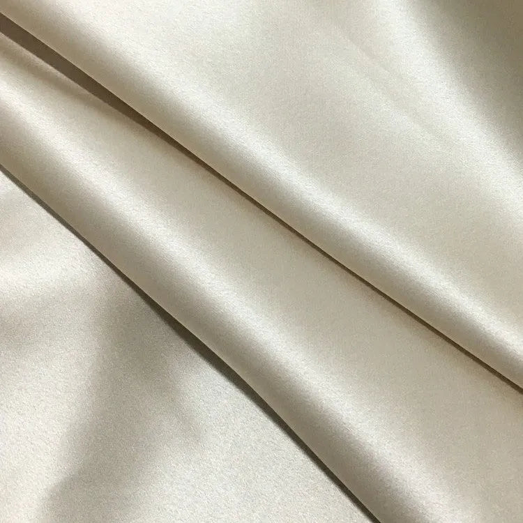 Dark grey envelope closure silk pillowcase on a bed.