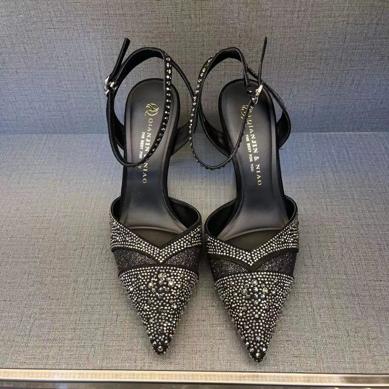Women's silver high heels with hollow cut-out design and red stiletto heel sole.