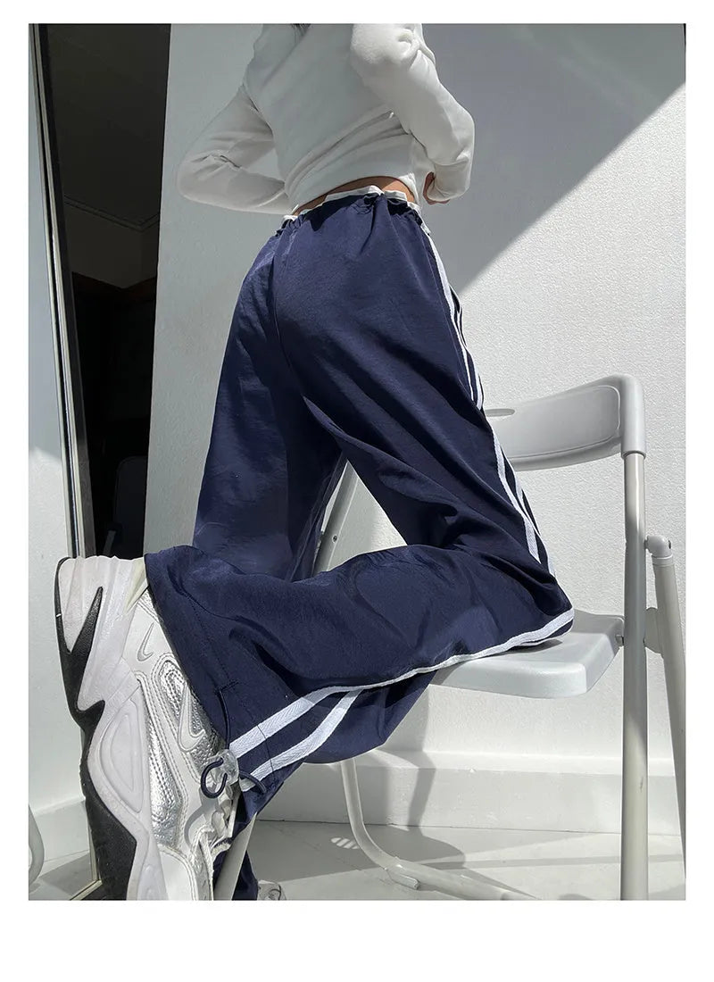 Women's navy blue loose straight-leg trousers with thin fabric and ribbon parallel bars contrast detail.
