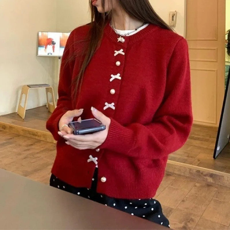 Women's cashmere cardigan sweater with bow and pearl buttons across chest in light blue colour