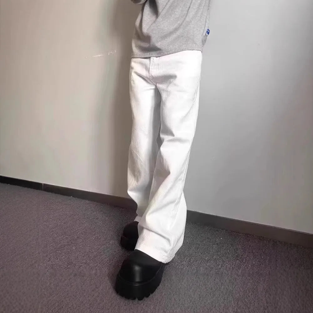 Man wearing loose straight-leg white denim jeans with a wide leg opening.