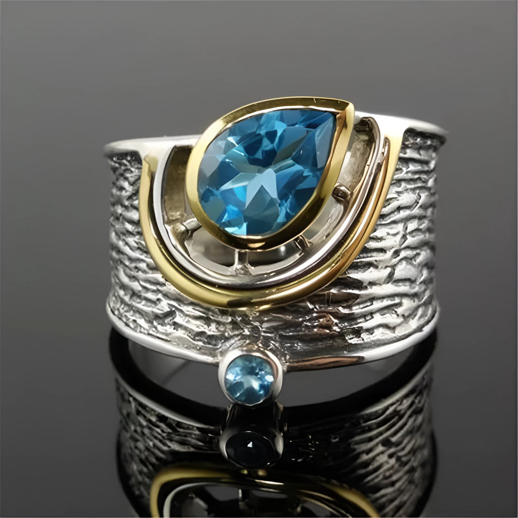 Blue Chinese style alloy ring with inlaid rhinestones in a drop shape on a white background.