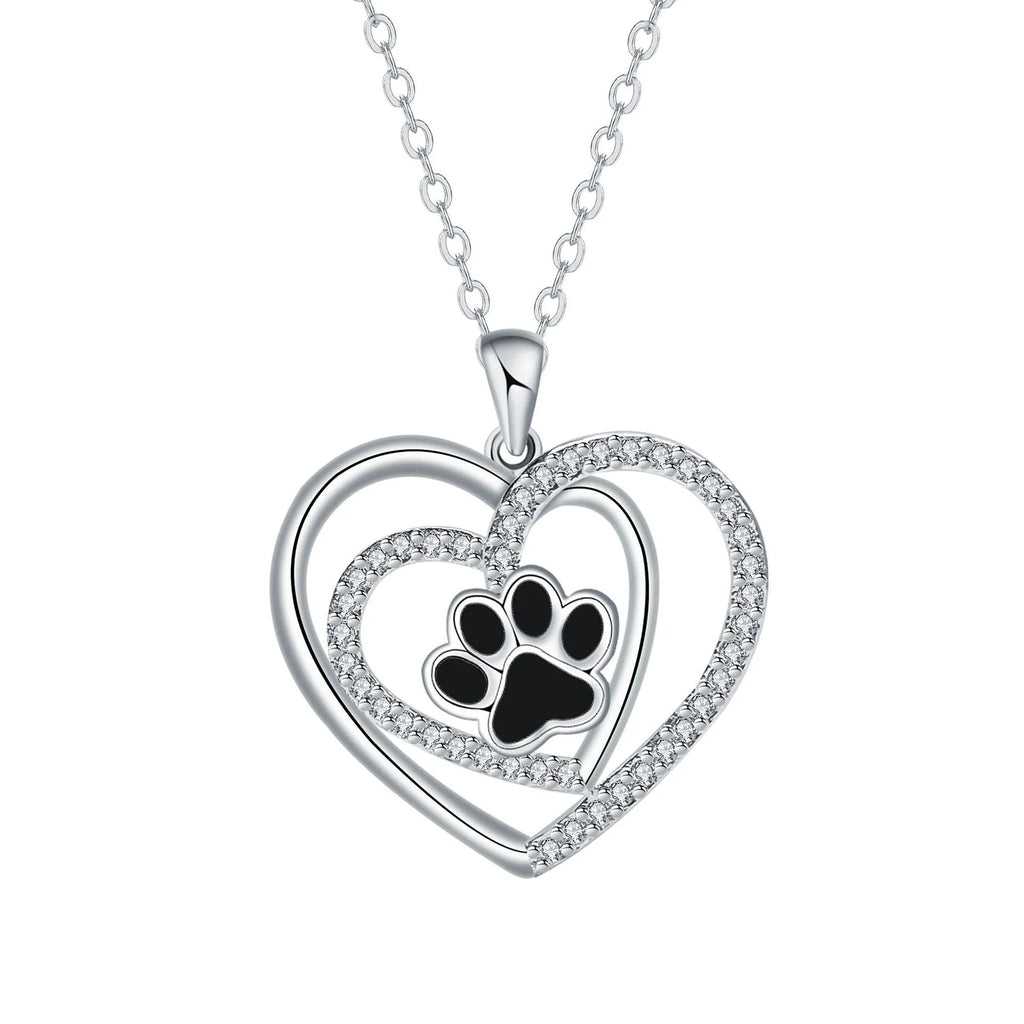 Women's dog paw print necklace with heart-shaped pendant on a cross chain.