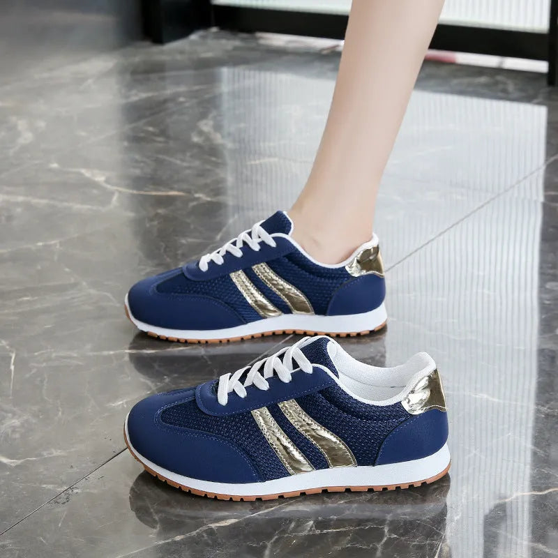 Blue women's artificial leather tennis shoes with cross shoulder straps and flat rubber sole.