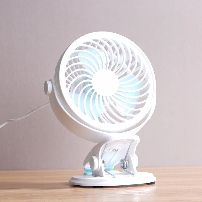 White USB desk fan with clip attachment and three blades, shown on a desk.