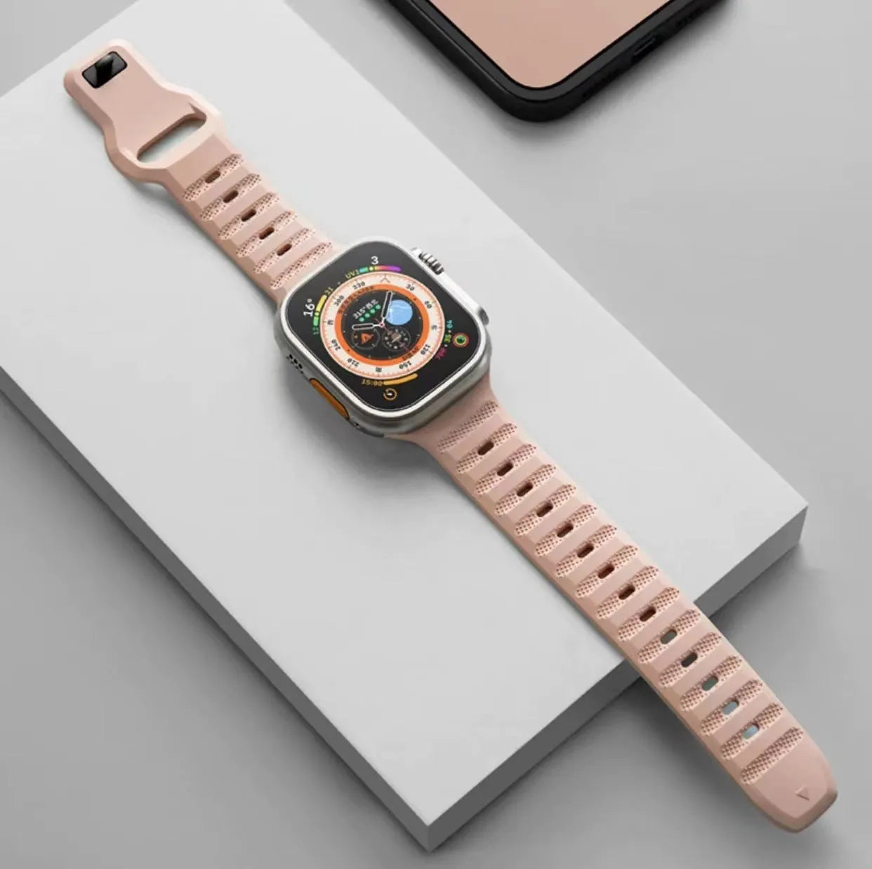 Fluoro rubber Apple Watch replacement band in multiple colours with T buckle, shown next to an Apple Watch.