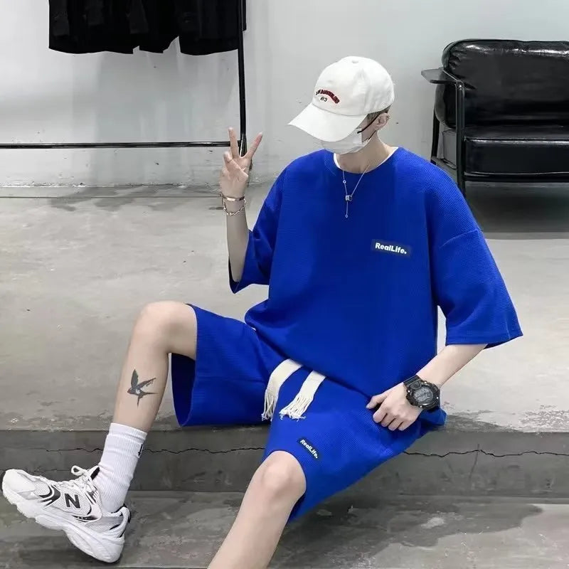 A waffle-textured leisure sports suit consisting of a short-sleeve top and shorts, shown in blue.