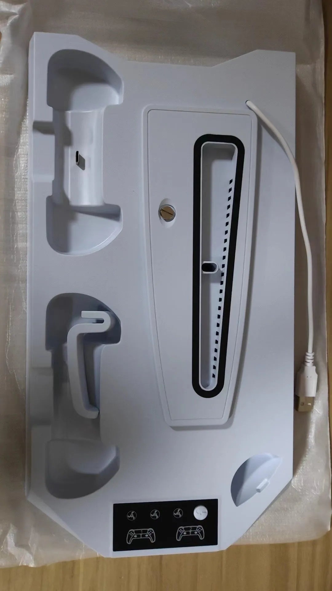 Black PS5 charging and cooling stand holding a console, controller, and headset.