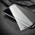 Tempered glass screen protector with 9H hardness for smartphones on a clean surface.