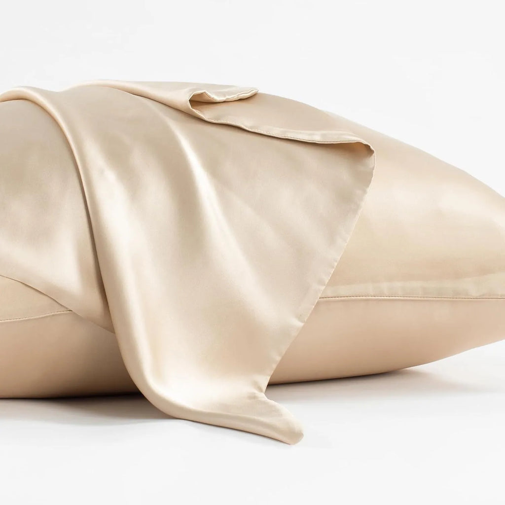 Dark grey envelope closure silk pillowcase on a bed.