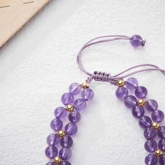 Handmade purple amethyst crystal bracelet with multi-treasure natural stone beads on white background