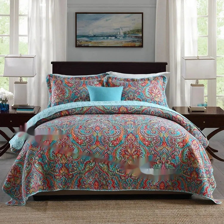 Quilted pure cotton bed cover set with printed pattern on a bed, includes two matching pillowcases.